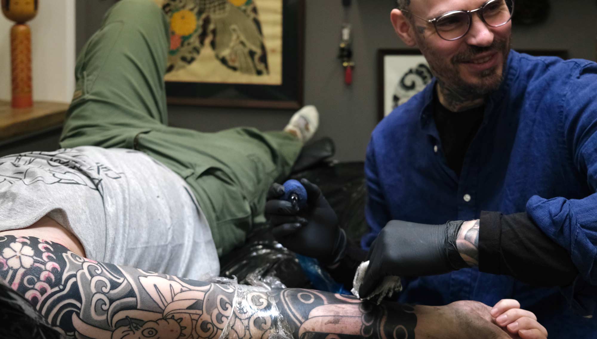 Swen Losinsky, Eigentümer von Good Old Times Tattoo Berlin, tätowiert japanische Tattoos, Koi mit Wasser auf einem Arm, worüber er sich sehr freut.