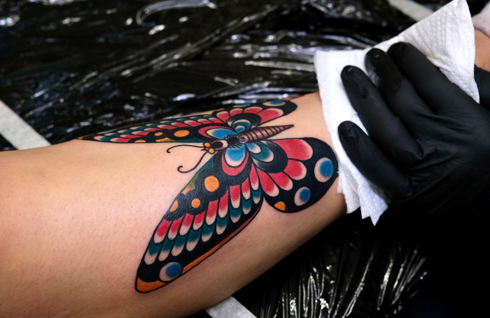 colorful traditional butterfly tattoo on shin