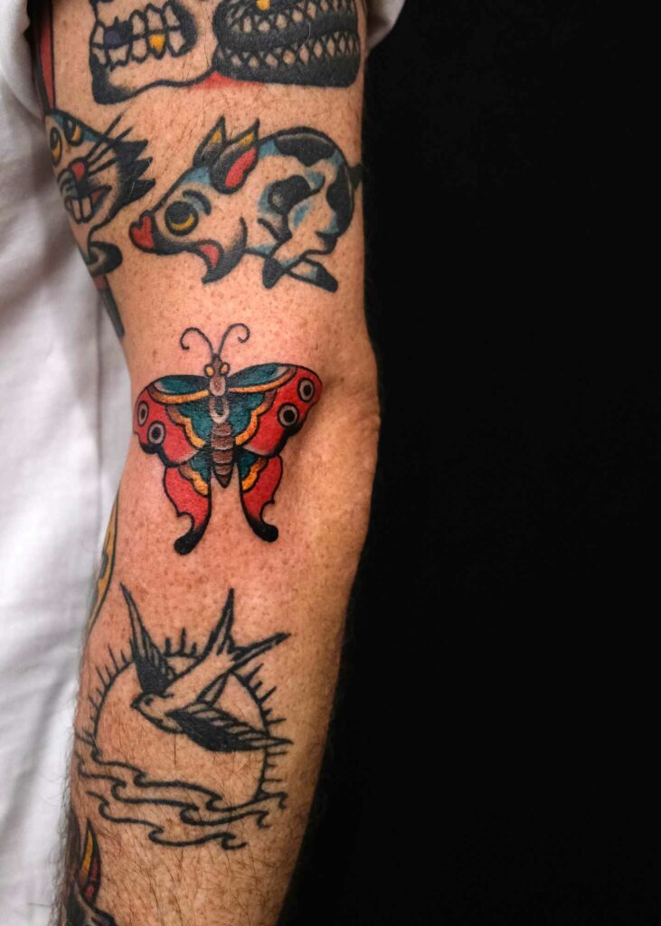 traditional butterfly tattoo next to elbow 