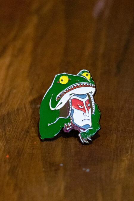 enamel pin featuring a kabuki frog front view