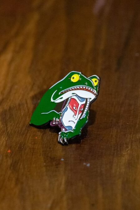 enamel pin featuring a kabuki frog side view